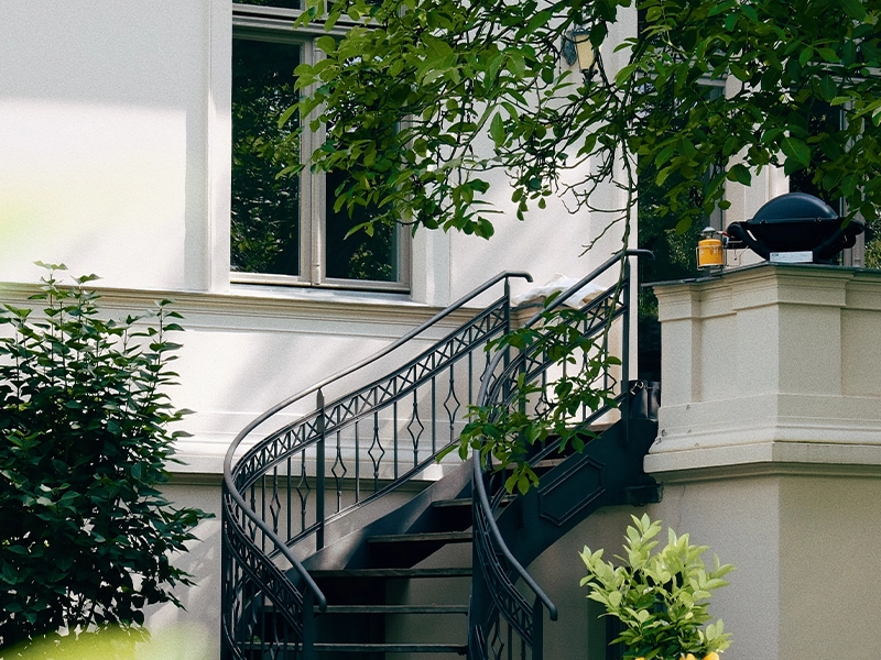 Hochwertige Außenfassade des luxuriösen Hauses mit toller geschwungener Wendeltreppe.