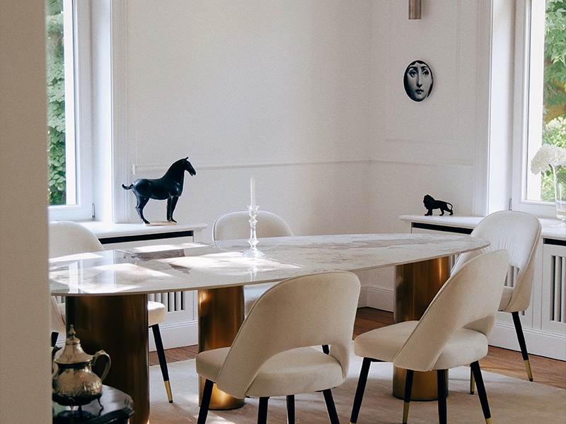 Zu sehen ist eine luxuriös eingerichtete Villa, mit Essbereich, Essstühlen und Dekor.