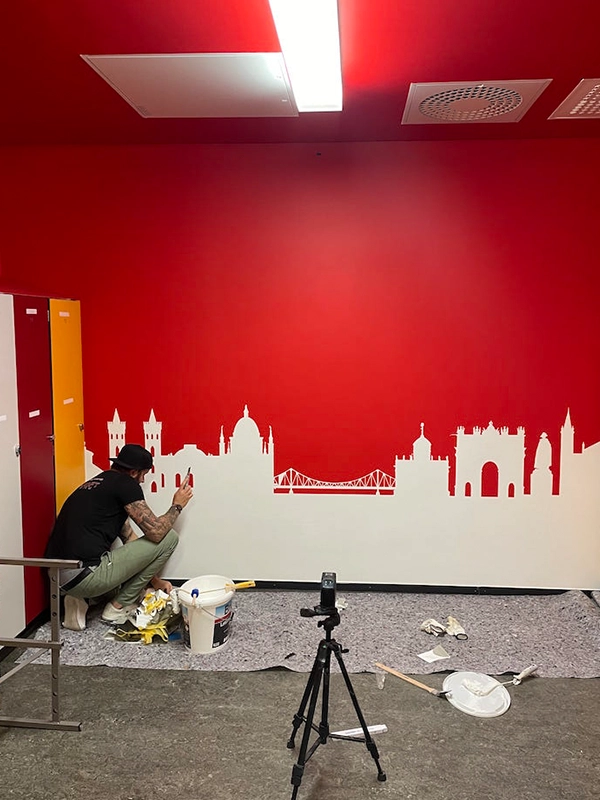 David Kraft, Inhaber von Kraftbau aus Potsdam, malert persönlich ein detailliertes Motiv für den SC Potsdam an die Wand.