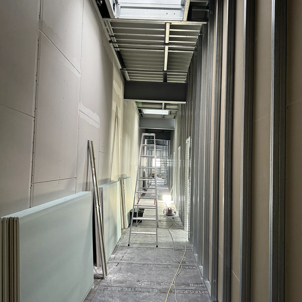 Trockenbauarbeiten im Innenausbau mit Metallständerwerk, montierten Gipskartonplatten und abgehängter Deckenkonstruktion in einem Gewerbeobjekt.